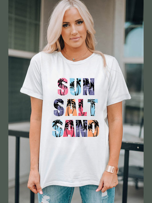Woman wearing white Letter Graphic Round Neck Tee with colorful "SUN SALT SAND" text and palm tree design