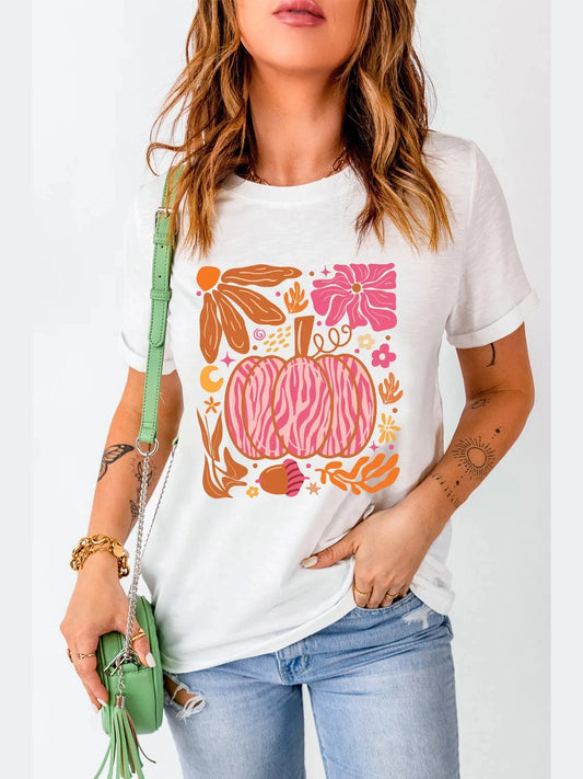 White graphic round neck short sleeve t-shirt with colorful pumpkin and floral design, slightly stretchy basic style, paired with light blue jeans and green handbag