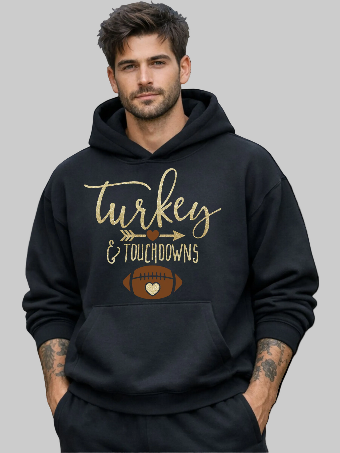 A man wearing a black pullover hoodie with a 'Turkey & Touchdowns' football graphic on the front, set against a plain white background.
