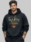 A man wearing a black pullover hoodie with a 'Turkey & Touchdowns' football graphic on the front, set against a plain white background.